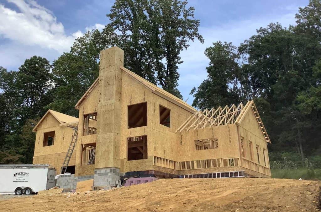 Modern wooden house frame in progress at a construction site by Quarry View Building Group.