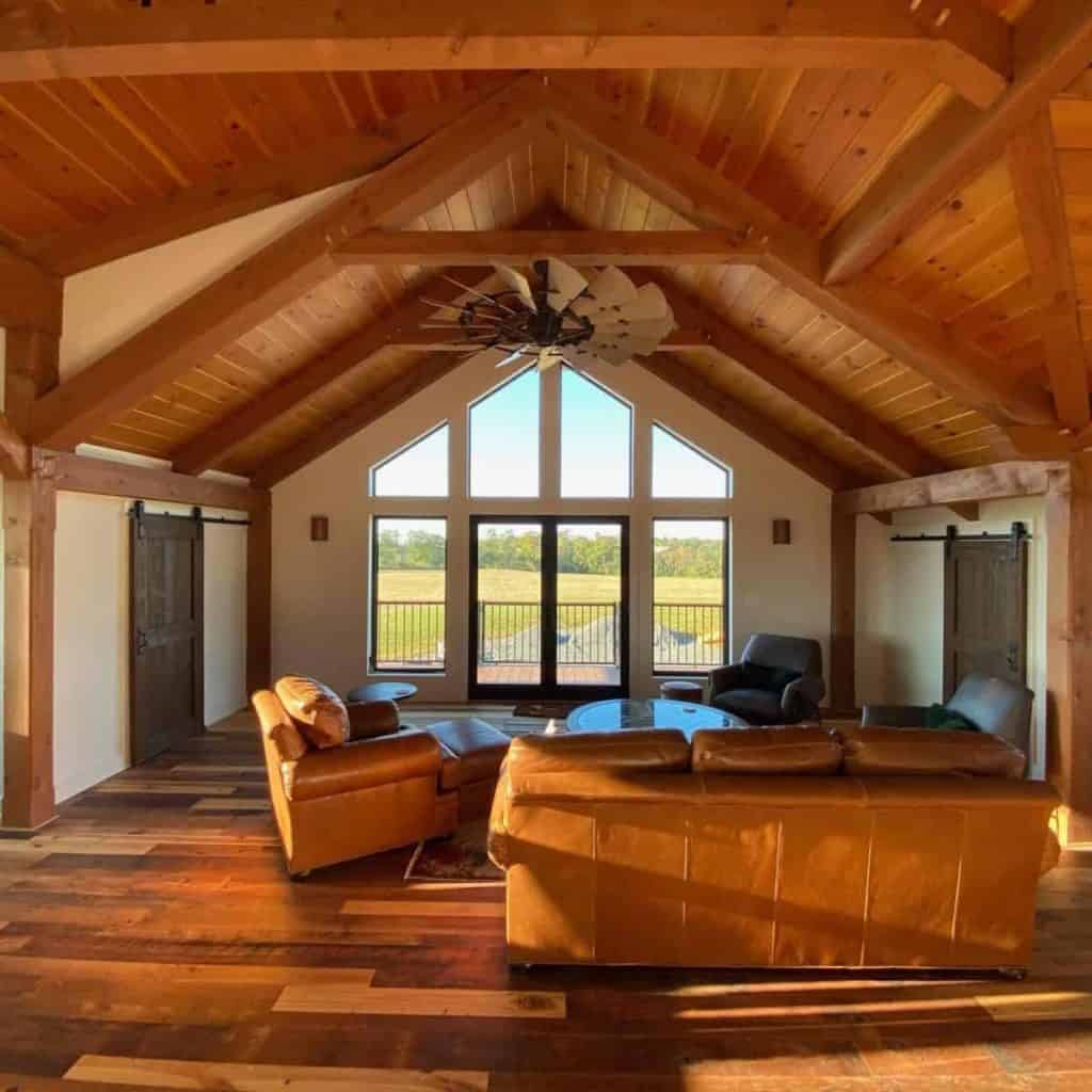 Spacious living room with wood vaulted ceiling, large windows, and scenic views.