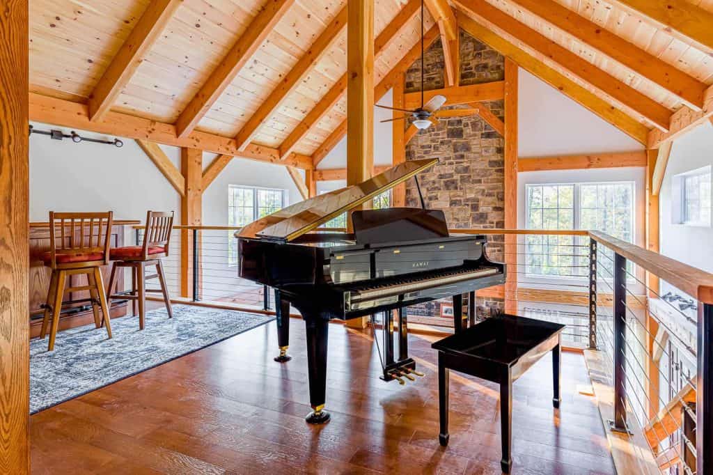 Elegant interior featuring a grand piano, timber beams, and large windows in a Quarry View Building Group home.