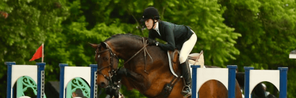 Horse rider jumping obstacle in competition, agility and equestrian sports scene.