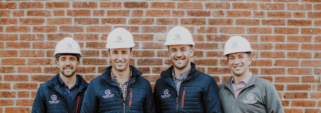 Workers wearing Quarry View hard hats and jackets posing outdoors.