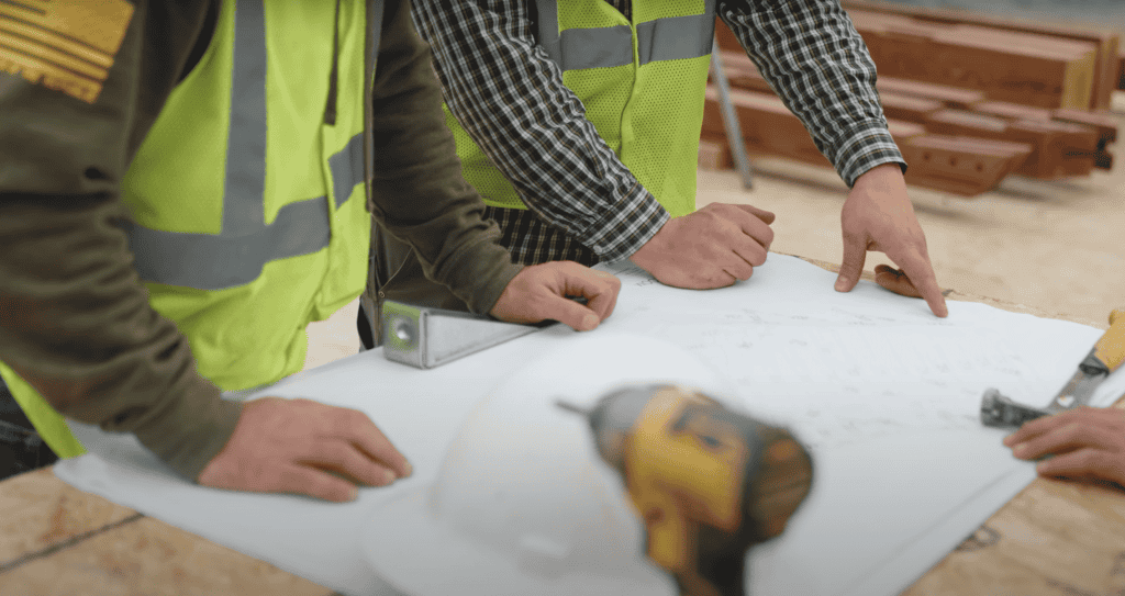 Construction team reviewing blueprints on site.