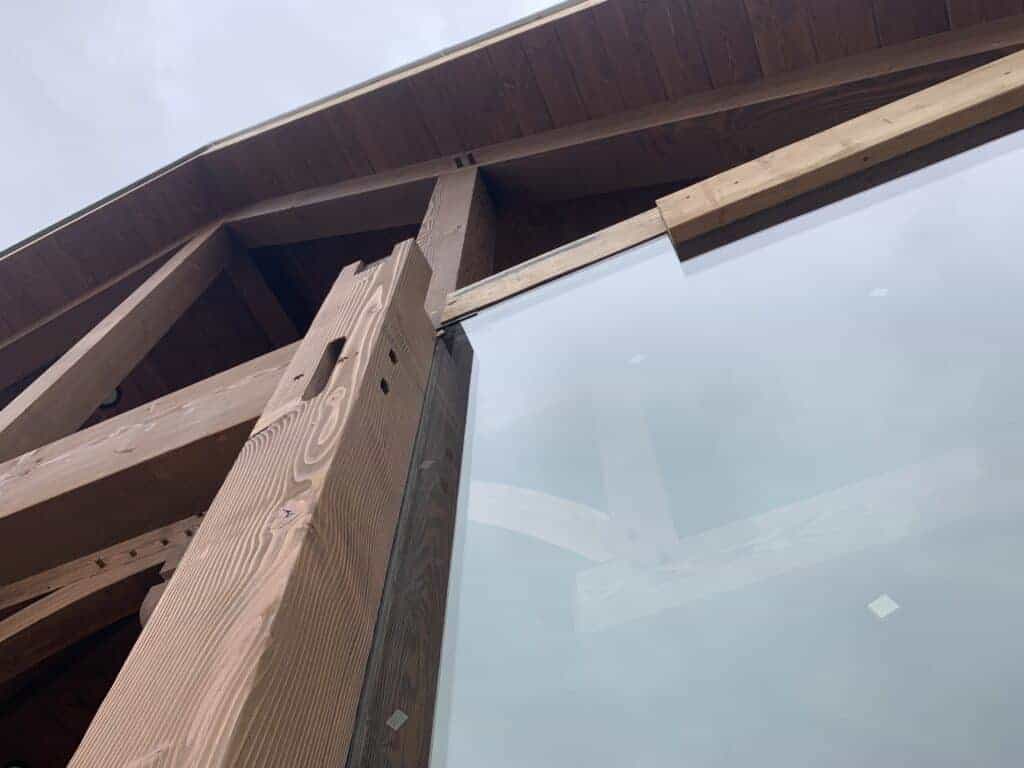 Unique building complex with brick house and barn style structure, showcasing custom architecture and landscape design.