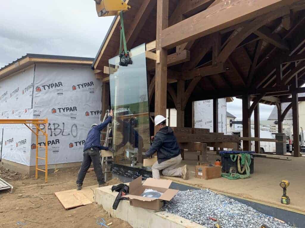 Unique building complex with brick house and barn style structure, showcasing custom architecture and landscape design.