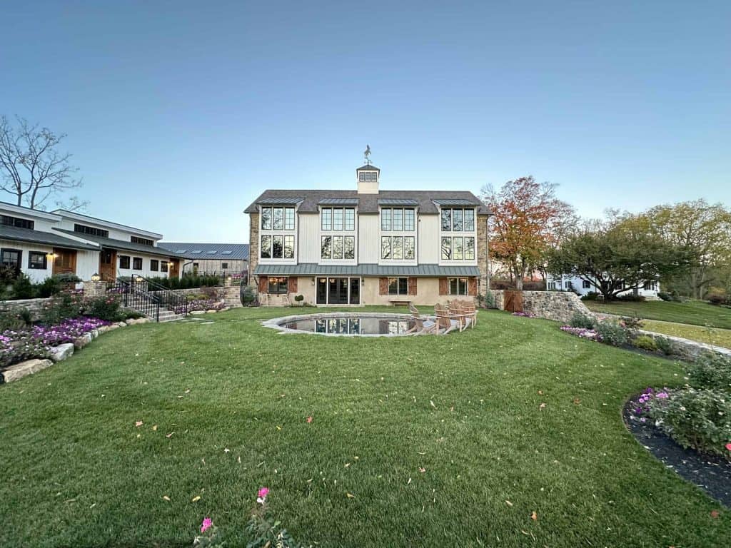 Modern house with large windows and garden landscape, showcasing quality construction skills.