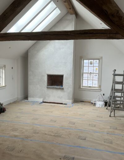 timber frame room under construction - white walls with dark exposed timber beams