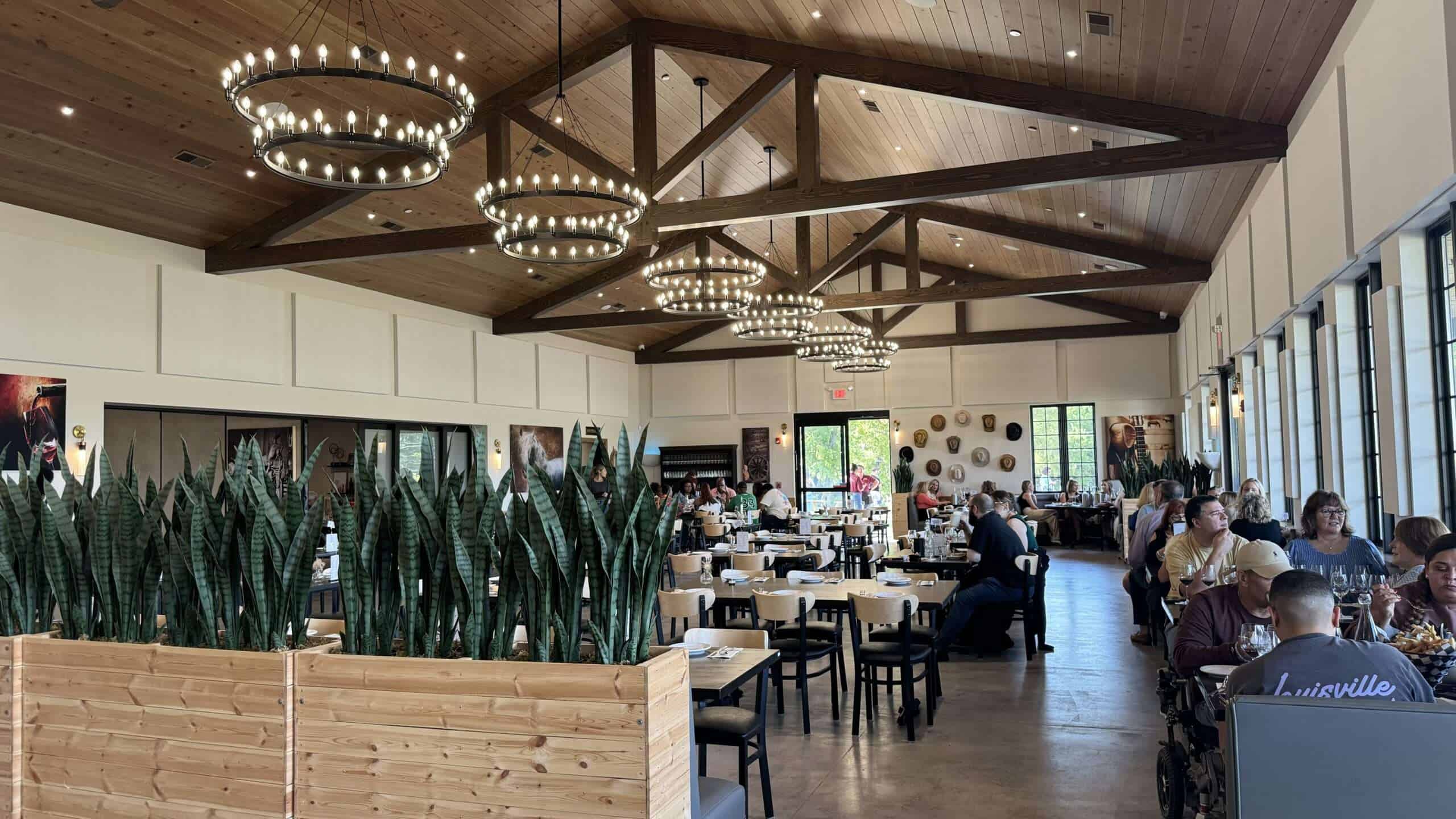 Elegant restaurant with wooden accents, pendant lighting, and spacious seating for dining comfort.