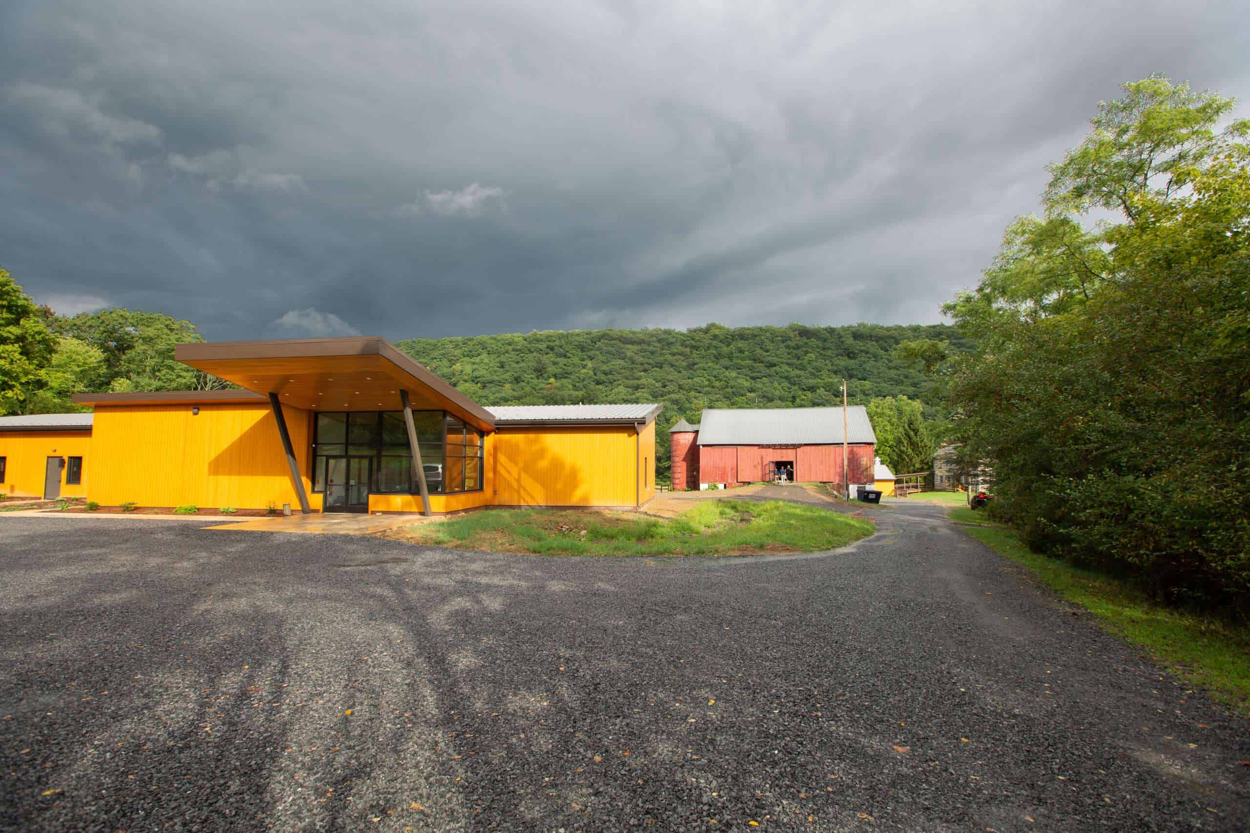 Colorful modern commercial building with vibrant yellow exterior and scenic mountain backdrop.