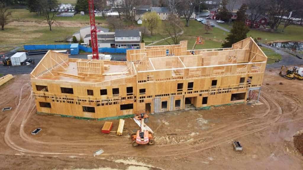 Construction site of a multi-story building under development, showcasing advanced framing and timber framework.