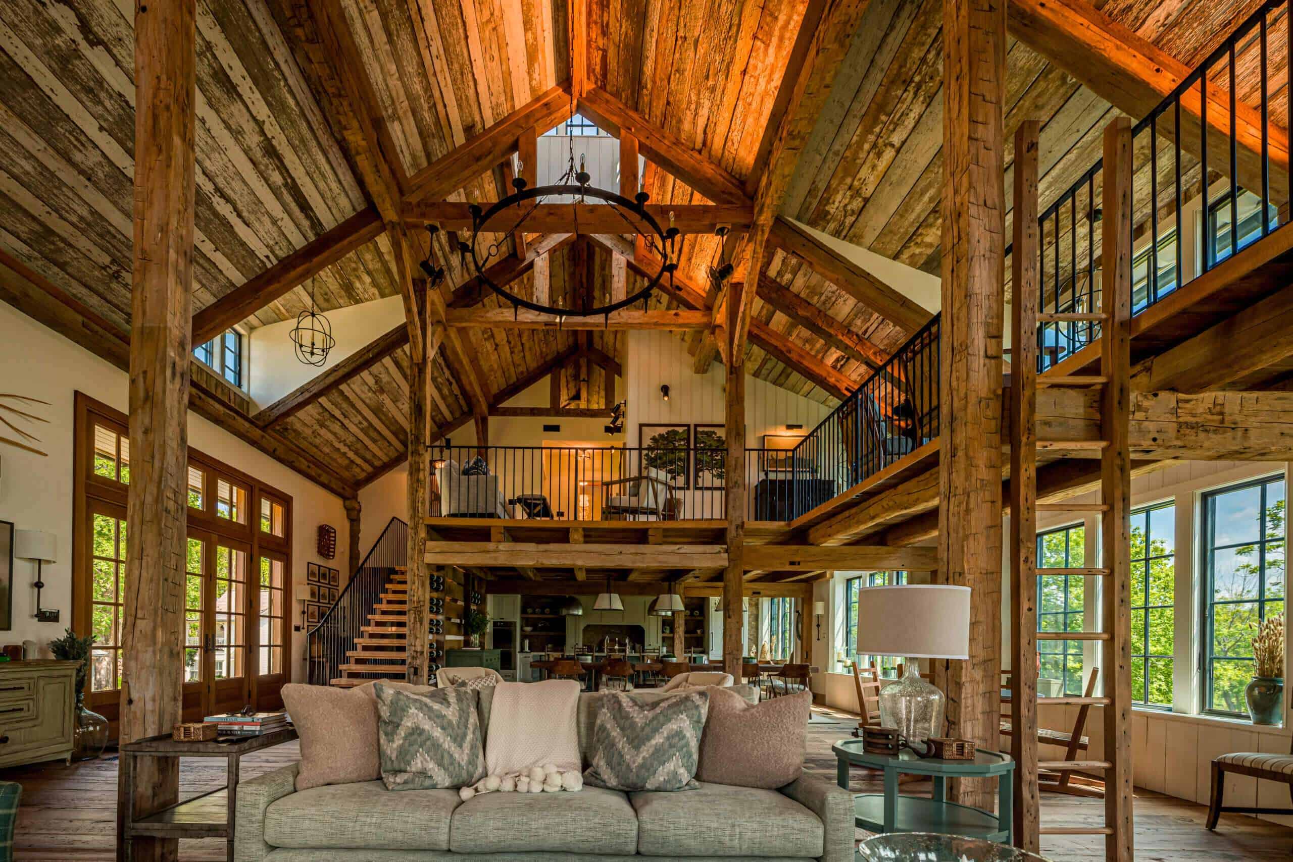 Bright open-concept oak timber living space with loft, large windows, and modern decor.