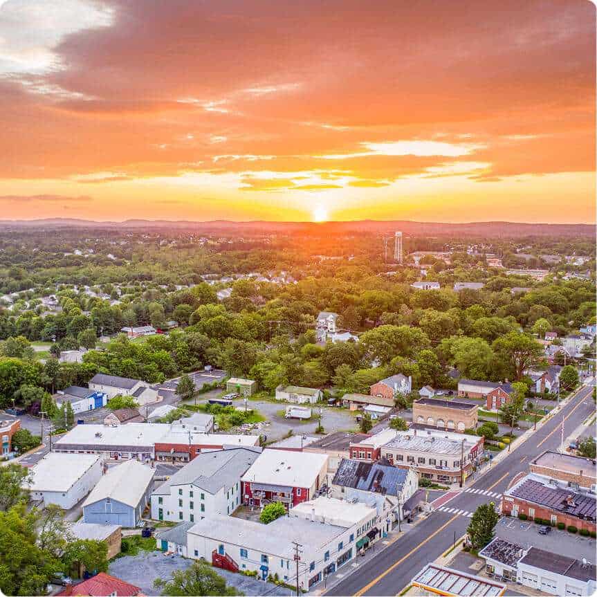 Aerial view of Quarry View Building Group with vibrant sunset sky over a charming townscape.