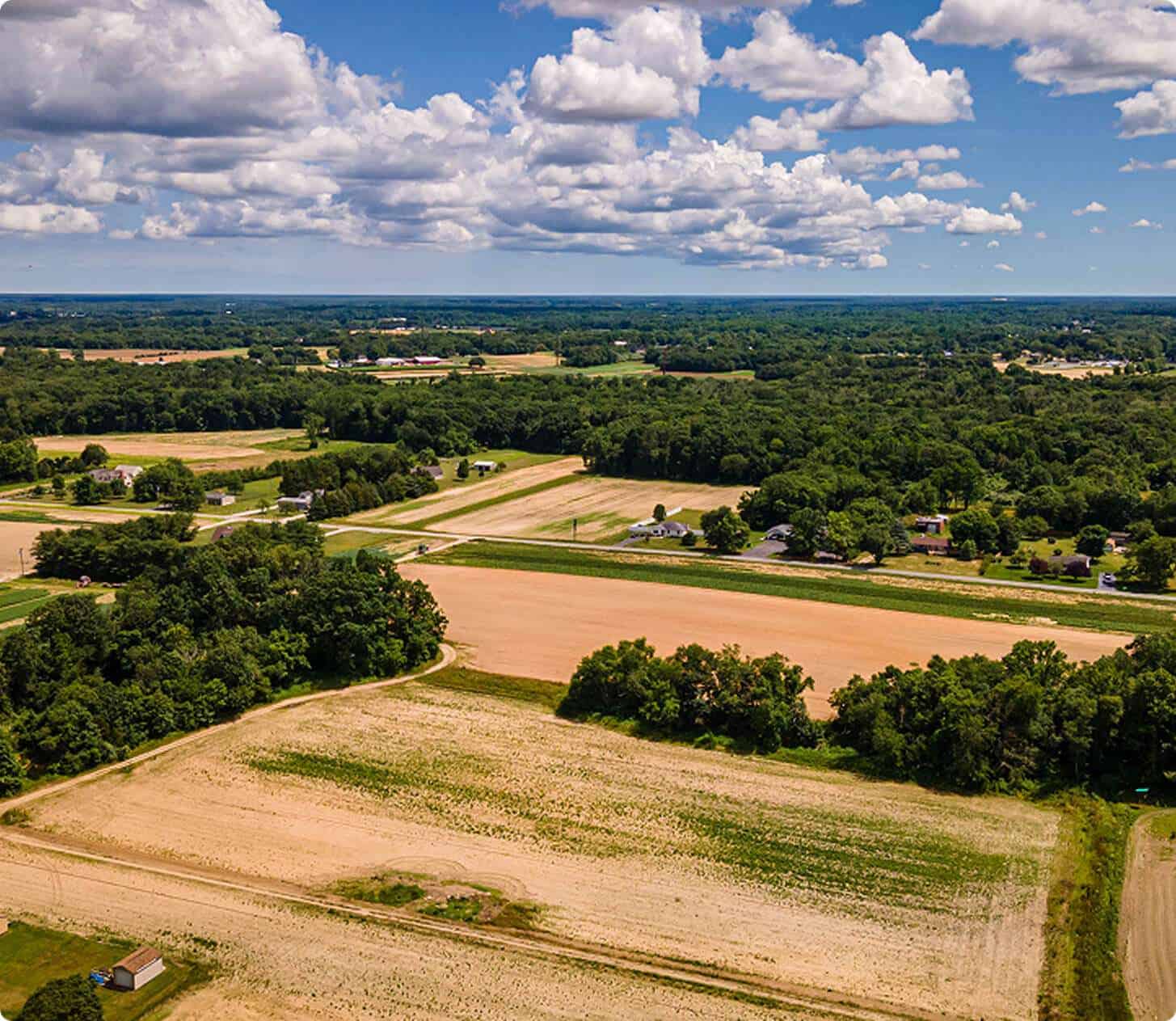 Aerial view of construction site with lush green landscape, open fields, and rural surroundings, showcasing Quarry View Building Group.