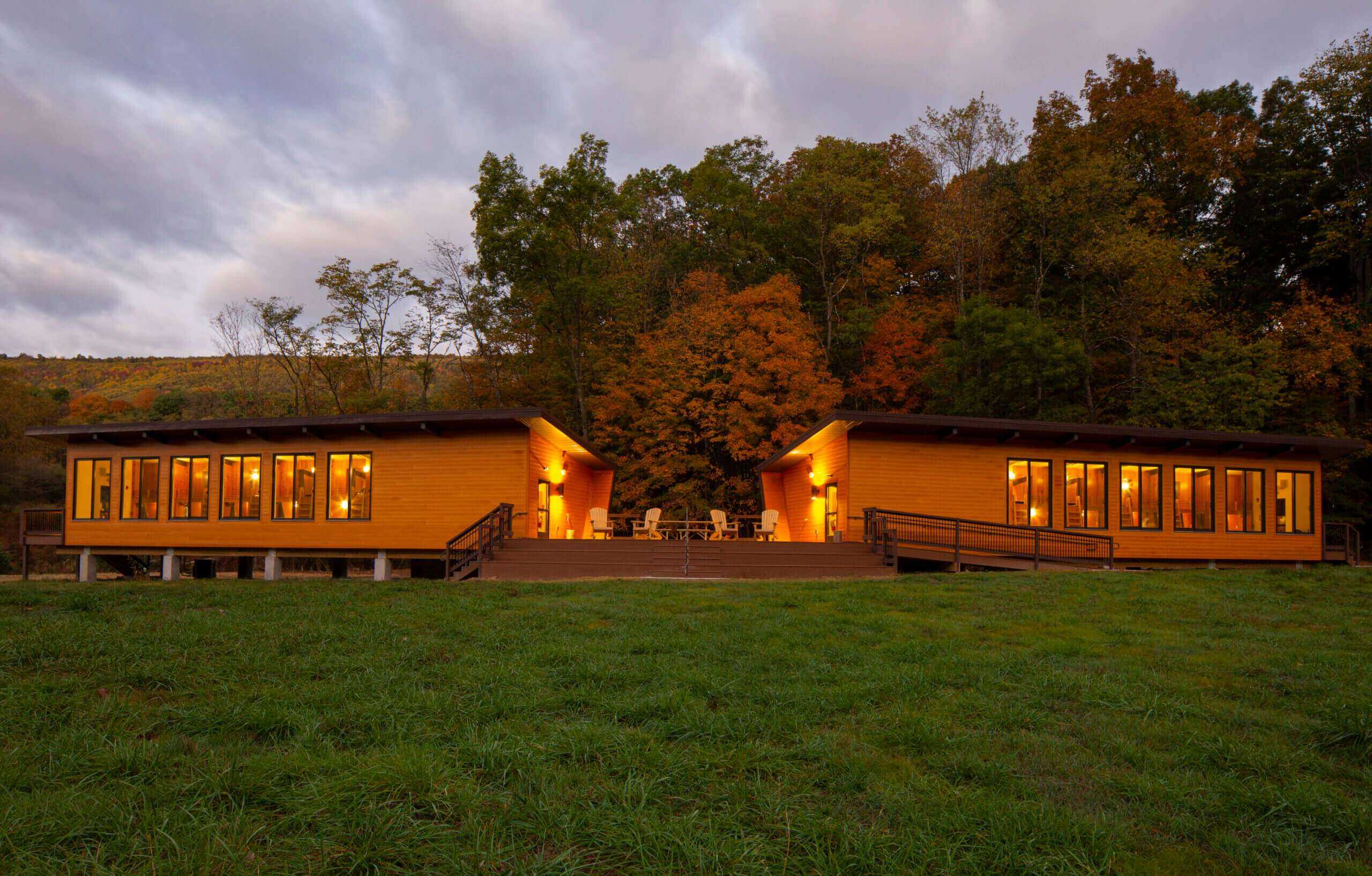 Bright, warm interior of custom timber-frame building at dusk.