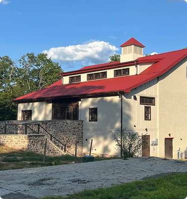 Modern commercial building with red roof and scenic surroundings.