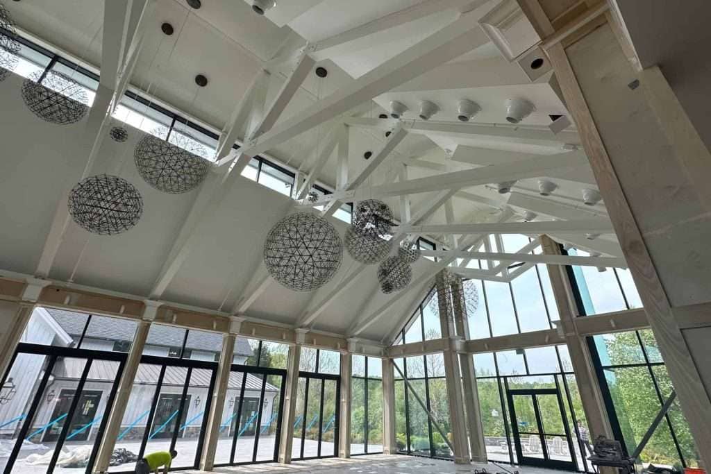 Flexible open space with high vaulted ceiling, large windows, and stylish lighting fixtures.