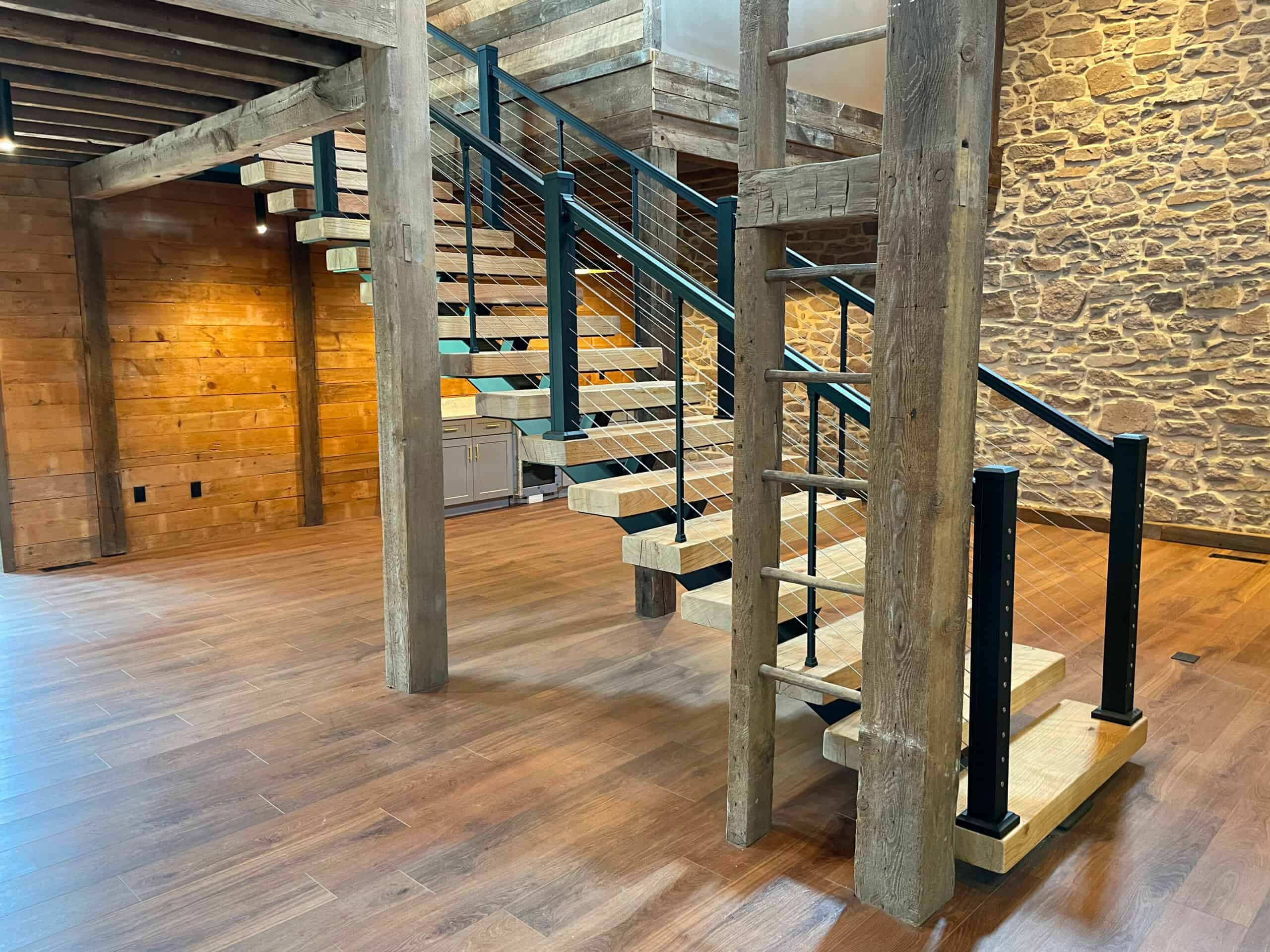 Modern rustic staircase with wood and metal design inside a stylish building.