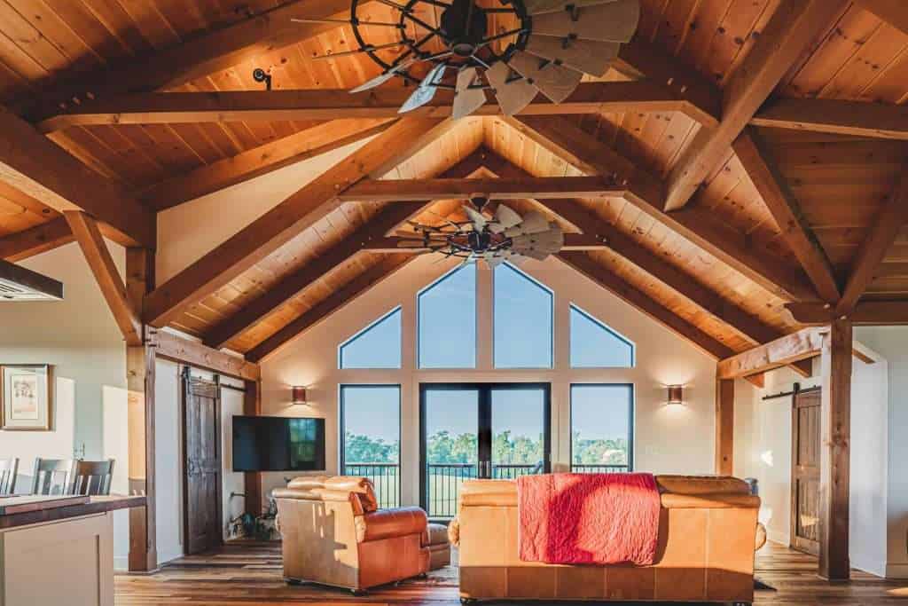 Spacious living room with vaulted wood ceiling, modern furniture, and scenic view.
