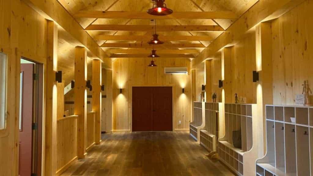 Elegant indoor hallway with wooden walls, ceiling, and modern lighting accents.