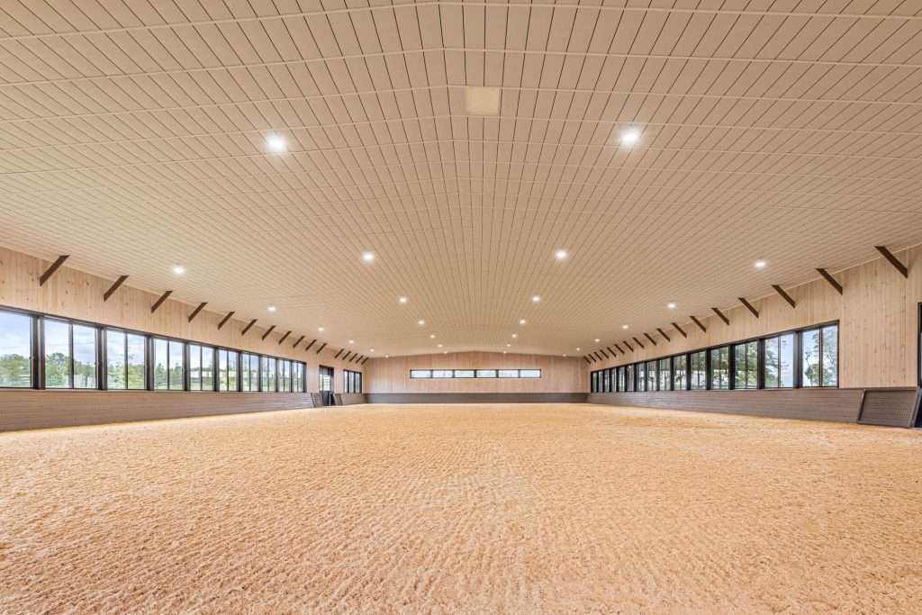 Indoor sports facility with wooden ceiling and ample windows for natural lighting.
