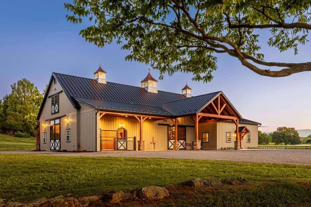 Rustic barn building with custom architecture by Quarry View Building Group, surrounded by lush landscape.