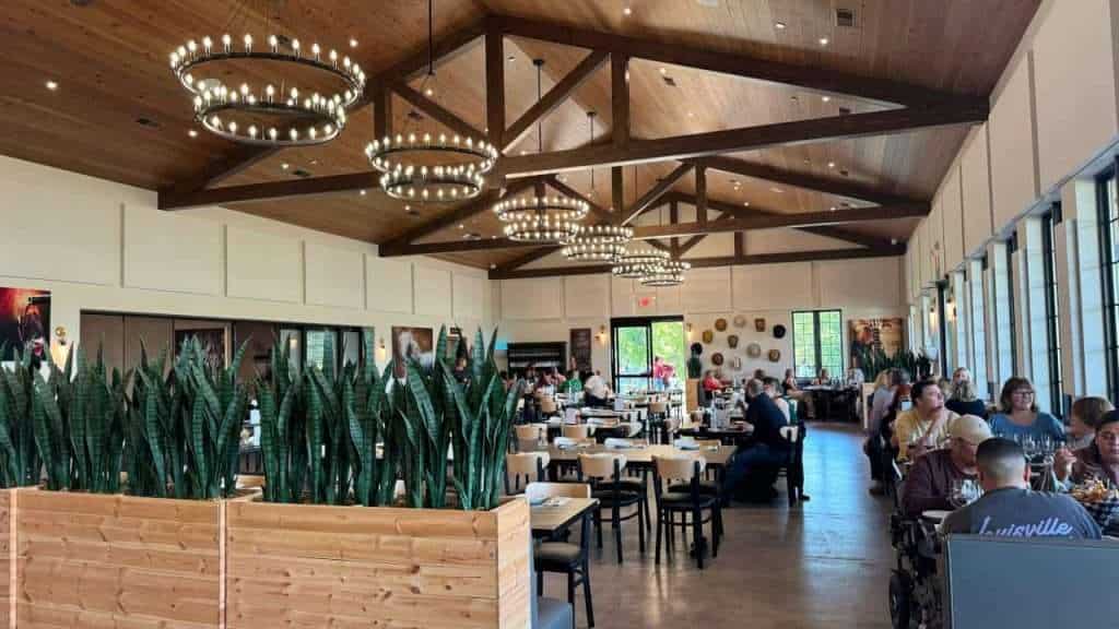 Modern restaurant interior with wooden accents and elegant lighting fixtures.