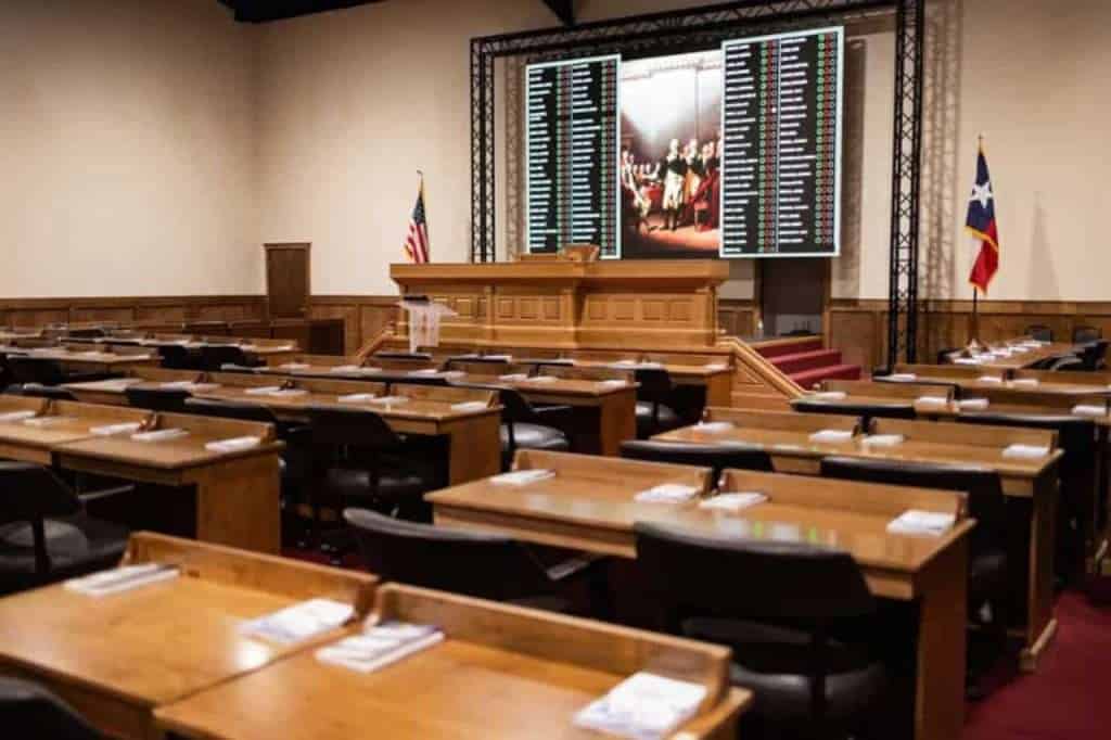 Modern boardroom with large digital screens and seating for meetings and events.