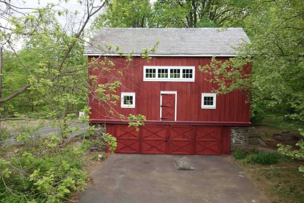 Barn building with traditional design, vibrant red exterior, white trim, and outdoor setting.