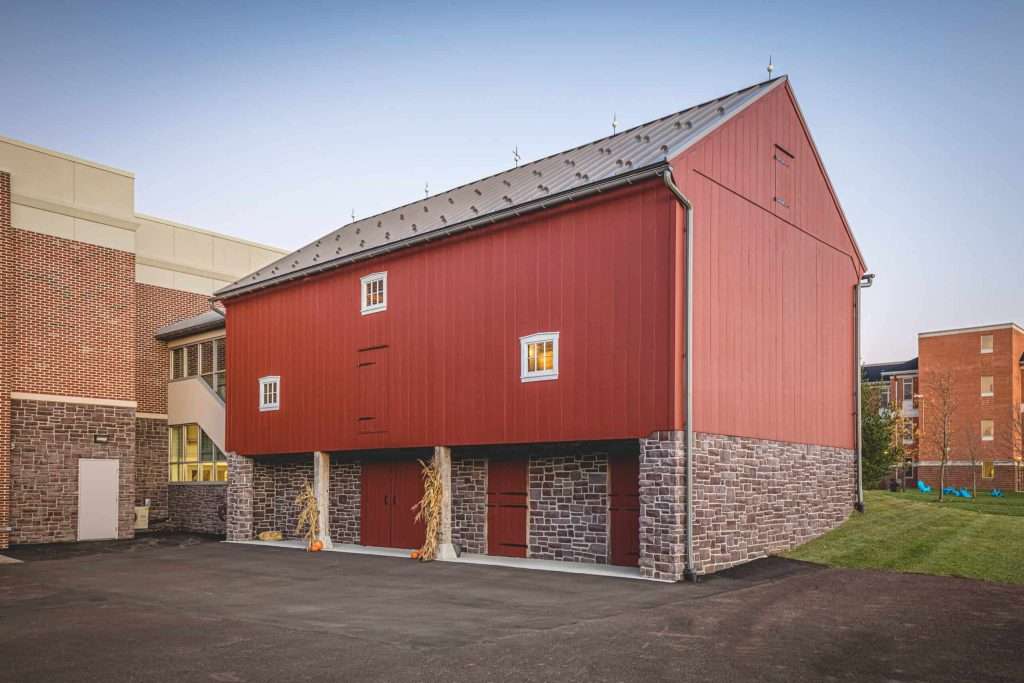 Stylish red building with stone foundation and small windows, showcasing modern commercial architecture.