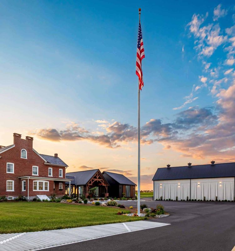 American flag flying near Quarry View Building Group project in a rural setting.