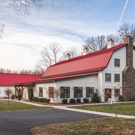 Rustic commercial building with white siding and red metal roof in Quarry View. Perfect for events or business use.