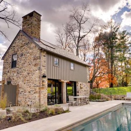 Charming stone house with pool and outdoor seating for renovation projects.
