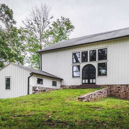 Modern barn-style building on lush green landscape.