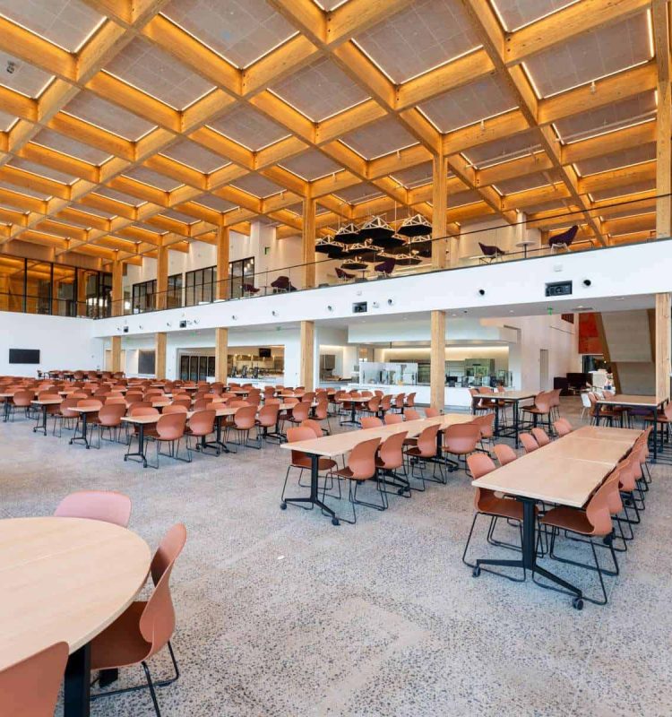 Bright, spacious event space with wooden beams, ample seating, and contemporary design for corporate gatherings.