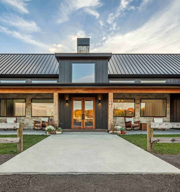 Spacious front porch with wooden beams and outdoor seating in a contemporary farmhouse design.