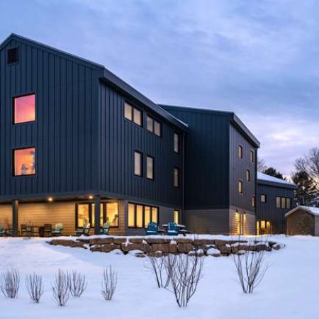 Contemporary Quarry View Building Group with sleek black exterior in winter landscape.