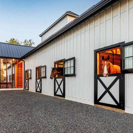 Bright horse stables with large windows and black-and-white accents. Perfect for equestrian enthusiasts.